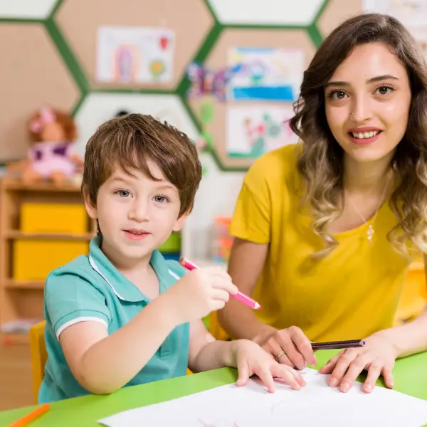 a boy sitting down and holding a pen