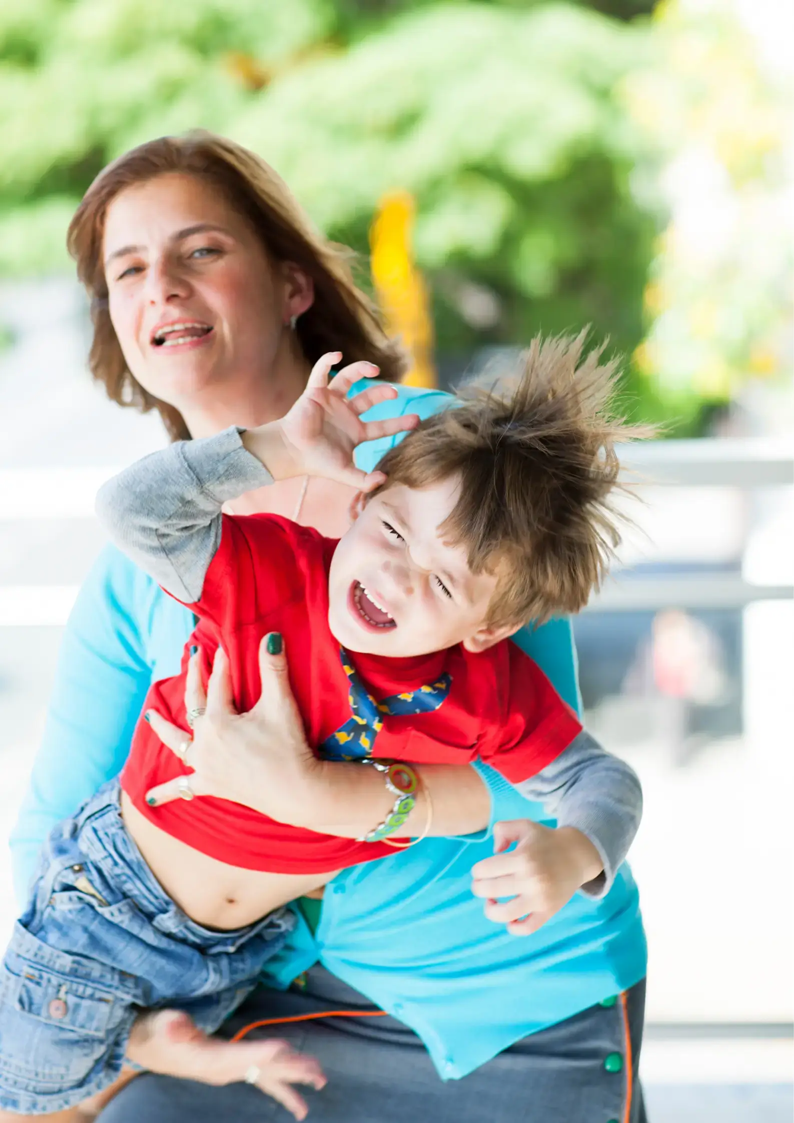 a mother holding toddler having tantrum