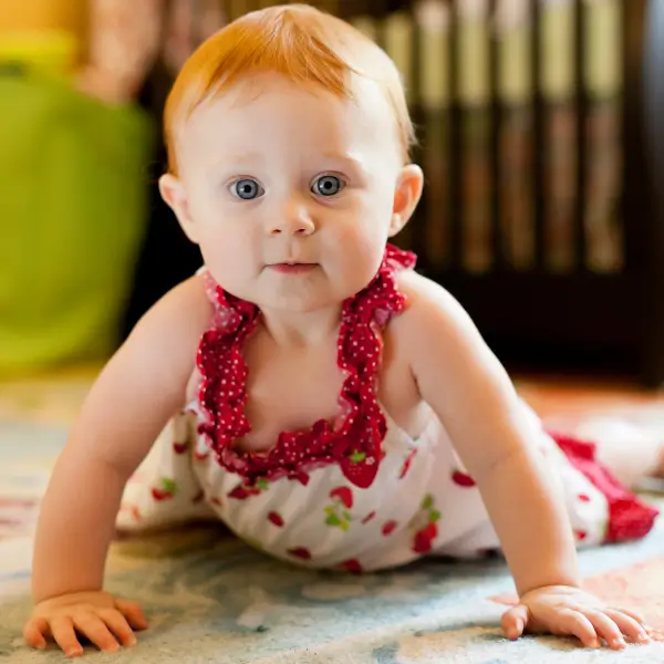 a Red haired baby crawling on the floor