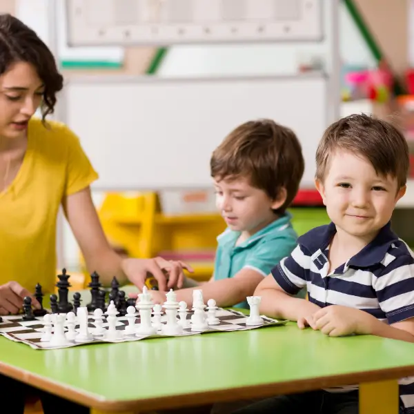 smiling toddlers playing chess game, expert parenting with teacher